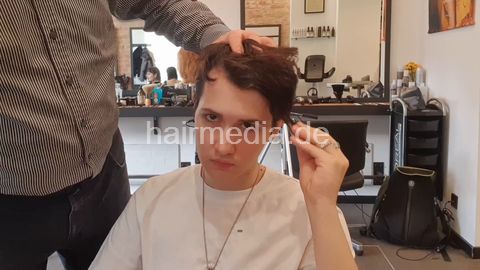 Artur pampering backward salon shampooing by barber, girlfriend is watching