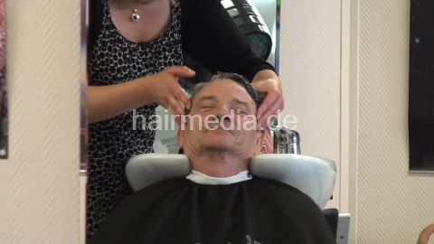 277 male client pampering backward hairwashing and haircut by blonde barberette