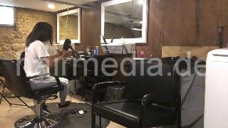 986 A lone in a row. African barberette washing her hair in salon forward over backward bowl