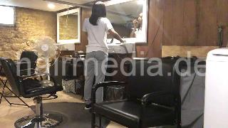 986 A lone in a row. African barberette washing her hair in salon forward over backward bowl