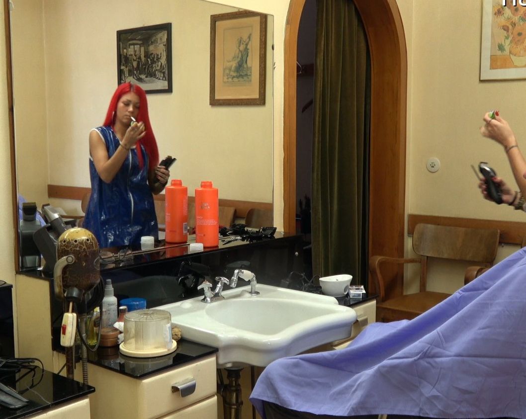 1034 smoking barberette Charline in blue vinyl apron 2 buzzing a male