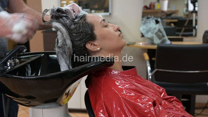 315 Barberette Hasna 4 backward shampooing by barber haircare in red PVC cape sideview