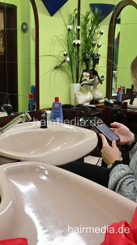 2303 VanessaH 2 chewing forward shampooings by barber in red cape - vertical video