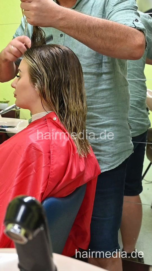 2303 VanessaH 3 chewing metal rollers wetset and hood dryer by barber in red cape - vertical video
