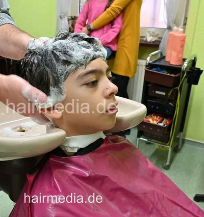 2308 Niklas 1 young boy pampering backward shampooing by barber, mom controlled