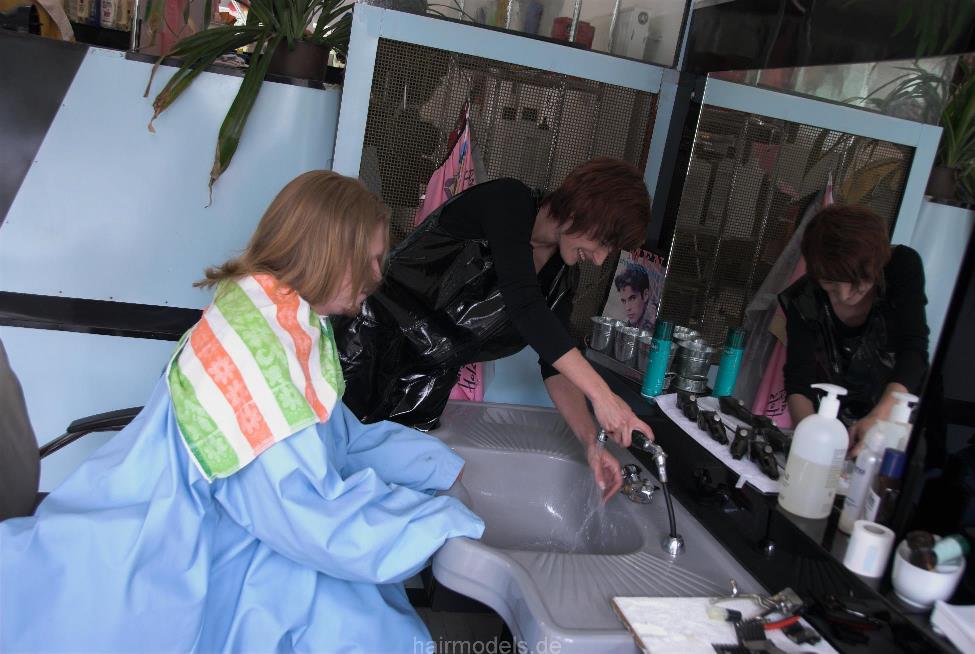 239 Benny 1 long hair guy in XXL cape shampooing forward manner in barbershop