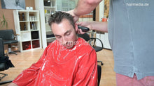 Load image into Gallery viewer, 2017 Niclas chewing 2 buzz clippercut dayly haircut by barber in red vinyl cape MTM