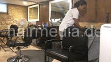 Laden Sie das Bild in den Galerie-Viewer, 986 A lone in a row. African barberette washing her hair in salon forward over backward bowl