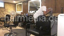 Laden Sie das Bild in den Galerie-Viewer, 986 A lone in a row. African barberette washing her hair in salon forward over backward bowl