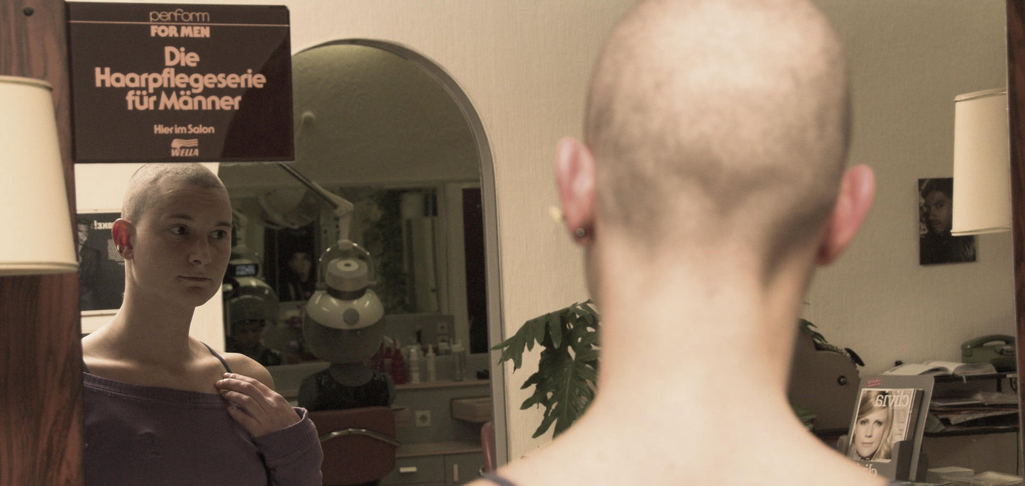 8064 Ilona 5 buzz Laura headshave by barberette in rollers and vinyl apron