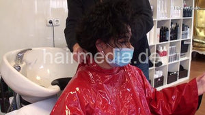 8162 Barberette Mirsada 1 backward wash by barber in her salon red heavy vinyl cape