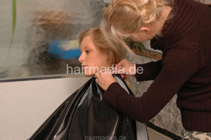 720 LenaG 1 fake perm shampooing forward manner hairwash in black vinyl cape and apron